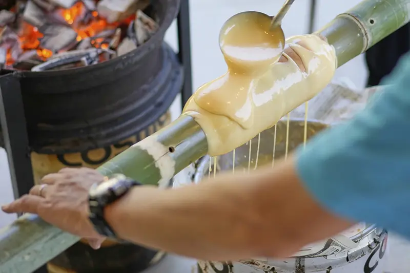 Staff make Baumkuchen, a German layered cake, during a workshop of Juchheim Ninoshima Welcome Center and Outdoor Activity Camp Monday, July 7, 2025, at Ninoshima island in Hiroshima, western Japan. (AP Photo/Eugene Hoshiko)