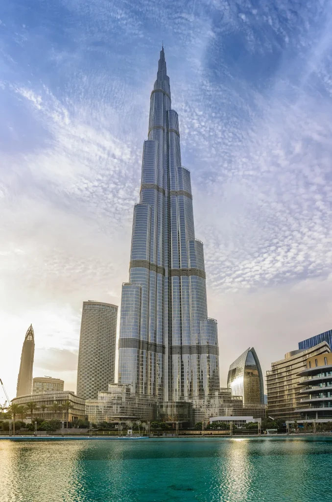 White and Grey Concrete Tower Beside Body of Water in Dubai, United Arab Emirates. Photo by Shukhrat Umarov